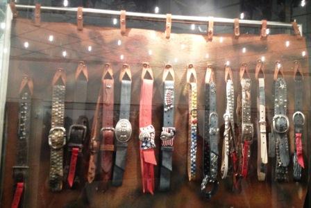 Accrocher des ceintures en cuir sur une peau tendue. Présentoir ceintures